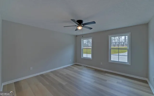 a view of empty room with wooden floor
