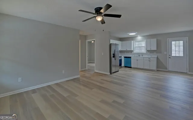 a view of a kitchen with a sink dishwasher a refrigerator and wooden floor