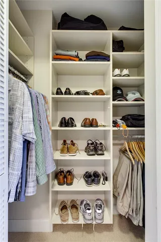 a view of walk in closet with clothes and shoes