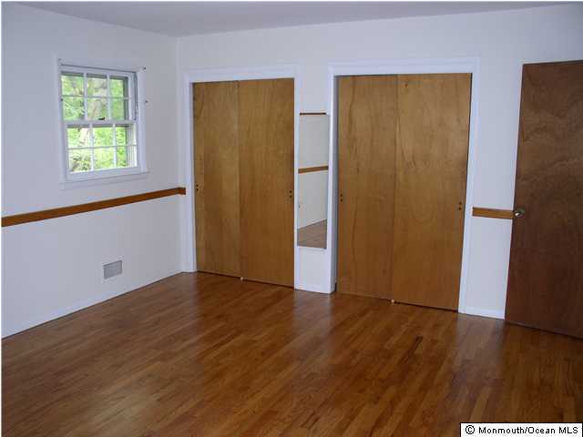 1303 Wedgewood Road Spring Lake, NJ 07762 - Photo 2 of 3 an empty room with wooden floor and windows