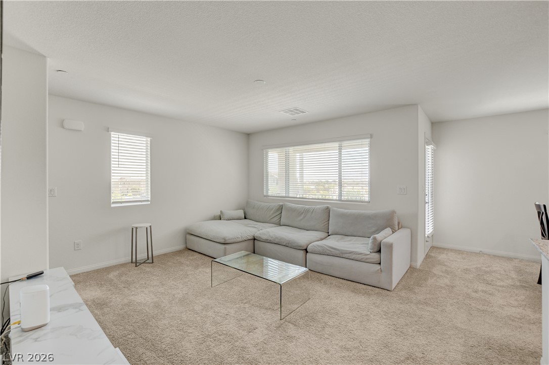 6924 Spicy Merlot Street North Las Vegas, NV 89086 - Photo 6 of 83 A well-lit interior space with plush carpet and ample natural light from multiple windows.
