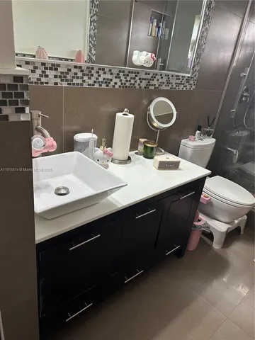 a bathroom with a sink mirror vanity and toilet