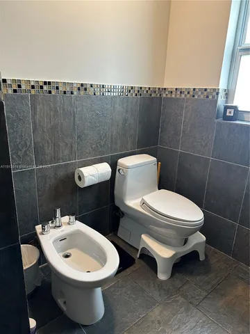 a bathroom with a toilet a sink and a mirror