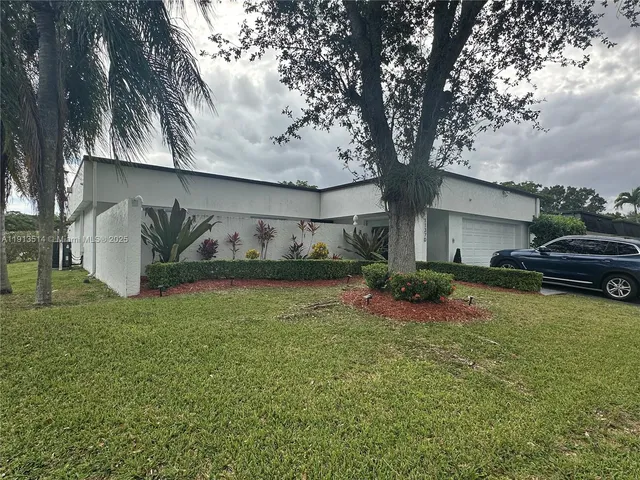 a kitchen with kitchen island granite countertop a sink cabinets and refrigerator