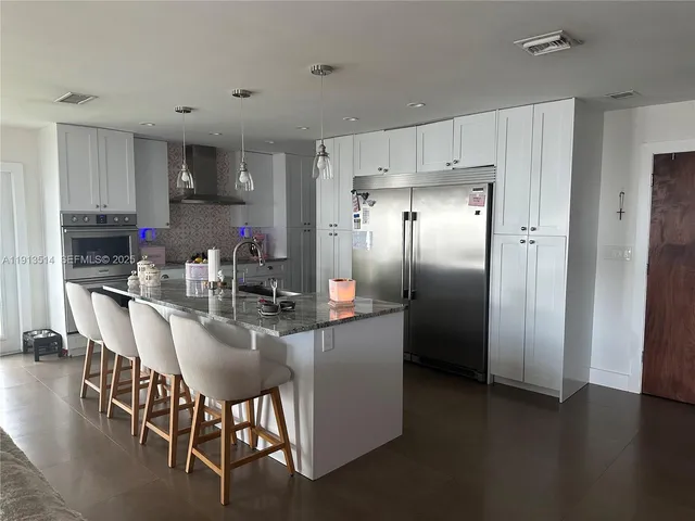 a kitchen with refrigerator cabinets and chairs