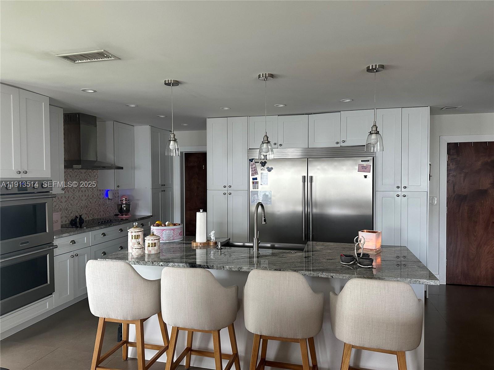 11370 Southwest 113th Terrace Miami, FL 33176 - Photo 10 of 27 a kitchen with refrigerator cabinets and chairs