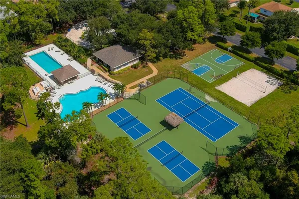 an aerial view of a tennis ground and a houses