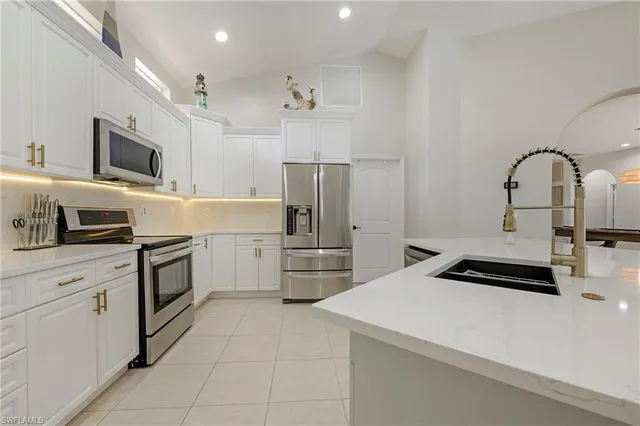 a kitchen with a refrigerator sink and cabinets