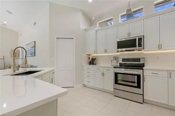 a kitchen with white cabinets stainless steel appliances and sink
