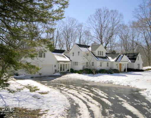 a view of a house with a yard covered in snow