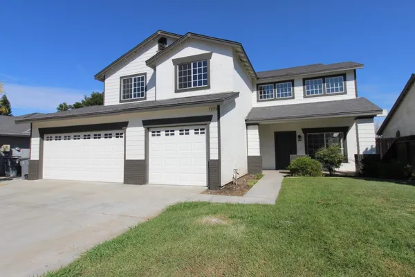 a front view of a house with a yard and garage