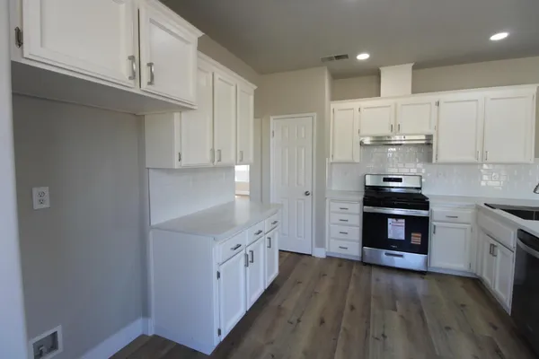 a kitchen with granite countertop a stove and a refrigerator