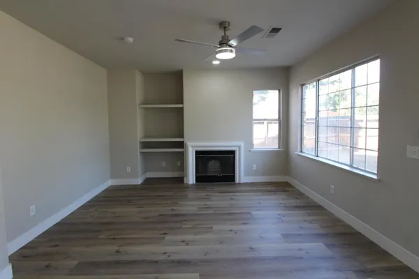 wooden floor fireplace and windows in an empty room
