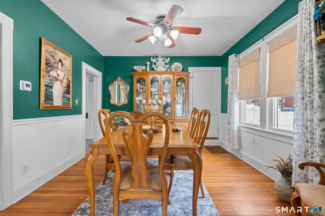 a dining room with furniture a chandelier and wooden floor