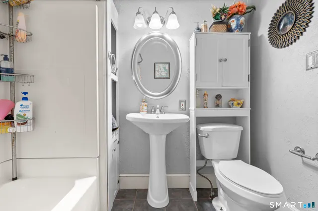 a kitchen with granite countertop wooden floors stainless steel appliances a sink and a window