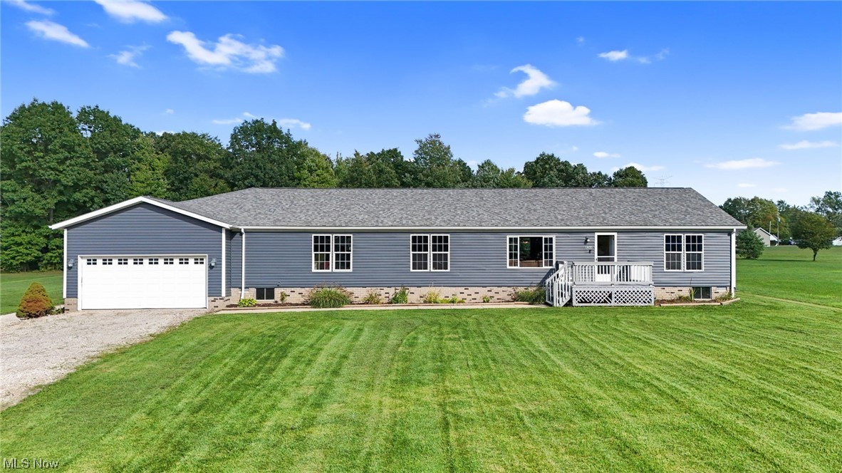 Ranch-style house featuring a front yard and garage