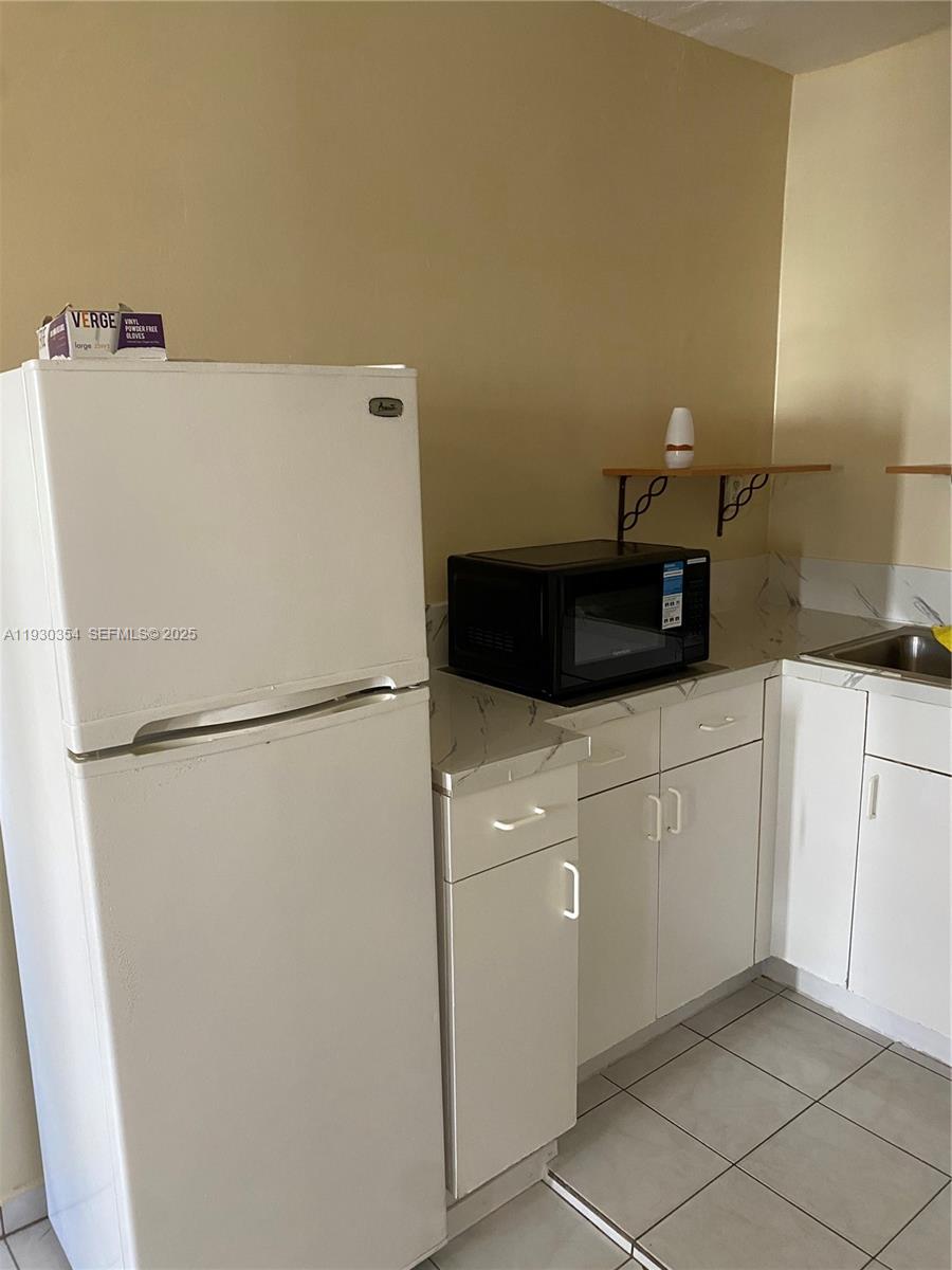 1062 West 42nd Place, Unit 41 Hialeah, FL 33012 - Photo 3 of 6 a white refrigerator freezer sitting in a kitchen