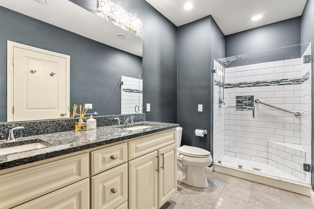 36 Owen Road, Unit 36 Norton, MA 02766 - Photo 19 of 40 a bathroom with a granite countertop sink a toilet a mirror and shower