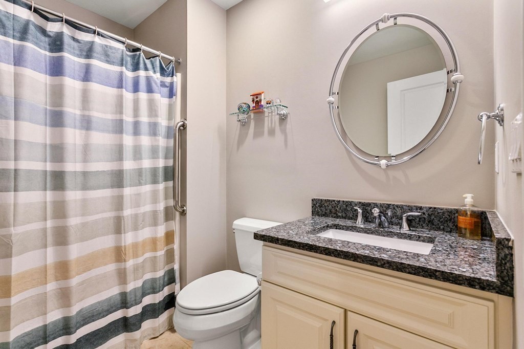 36 Owen Road, Unit 36 Norton, MA 02766 - Photo 25 of 40 a bathroom with a sink toilet a mirror and shower curtain