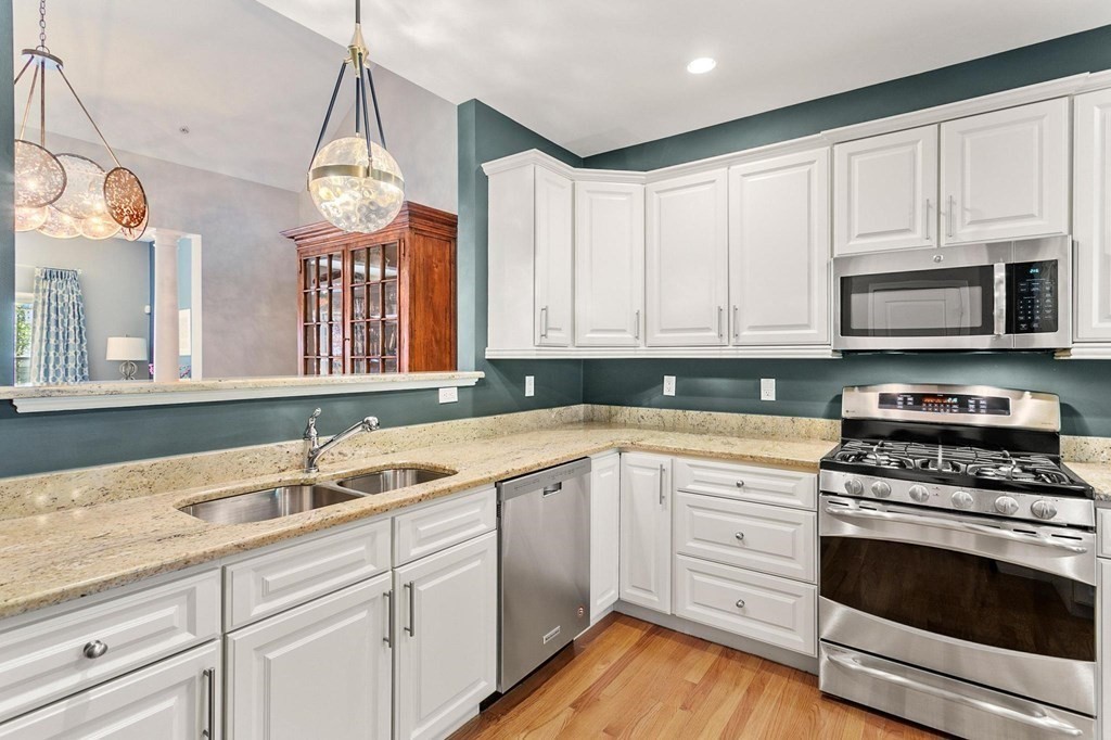 36 Owen Road, Unit 36 Norton, MA 02766 - Photo 5 of 40 a kitchen with granite countertop a sink stainless steel appliances and cabinets