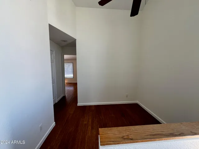 a view of a big room with wooden floor and windows