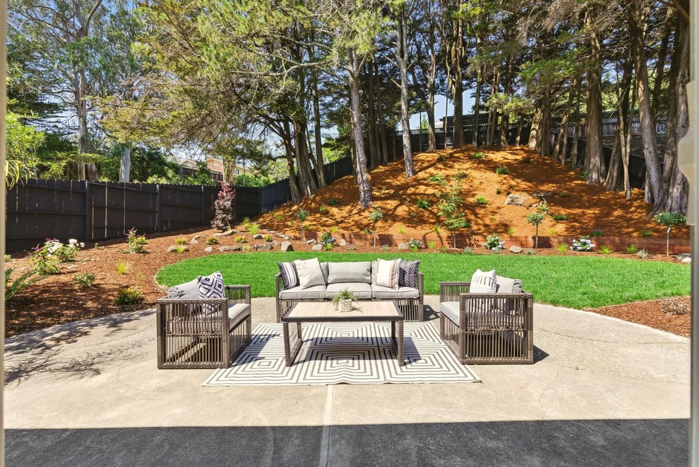 1807 Hunt Drive Burlingame, CA 94010 - Photo 34 of 46 a view of a patio with couches and a table and chairs with wooden fence and trees