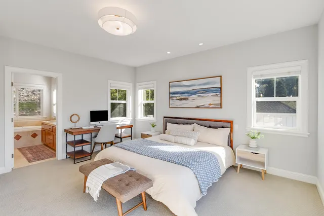 a bedroom with a bed and a large window