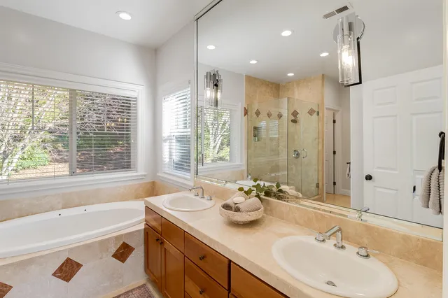 a bathroom with a tub sink and mirror