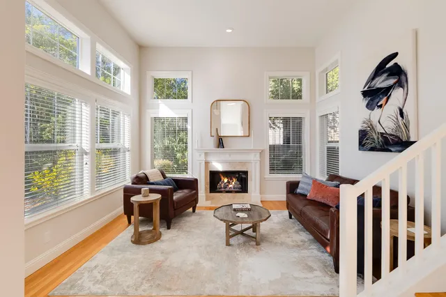 a living room with furniture fireplace and a large window