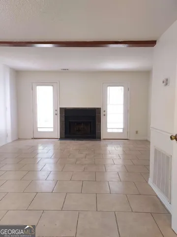 a view of empty room with a fireplace and windows