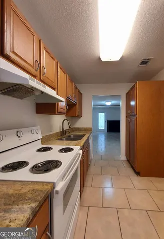 a kitchen with a stove a refrigerator and cabinets