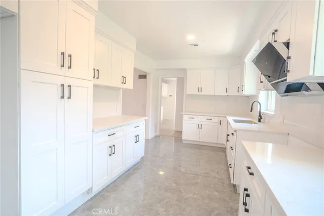 a large white kitchen with cabinets