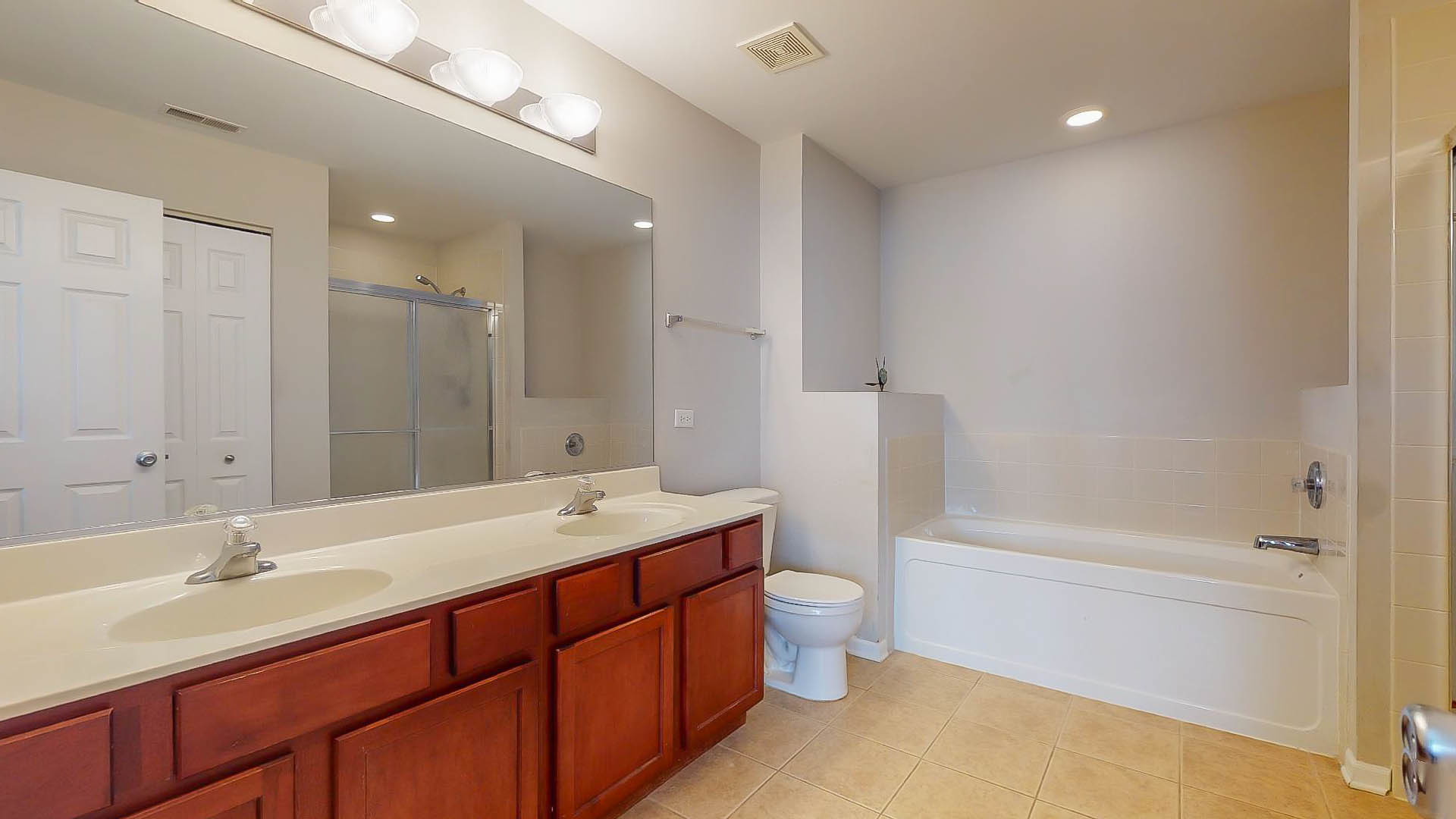 1916 West Cobblestone Road Romeoville, IL 60446 - Photo 12 of 21 a bathroom with a double vanity sink toilet mirror and bathtub