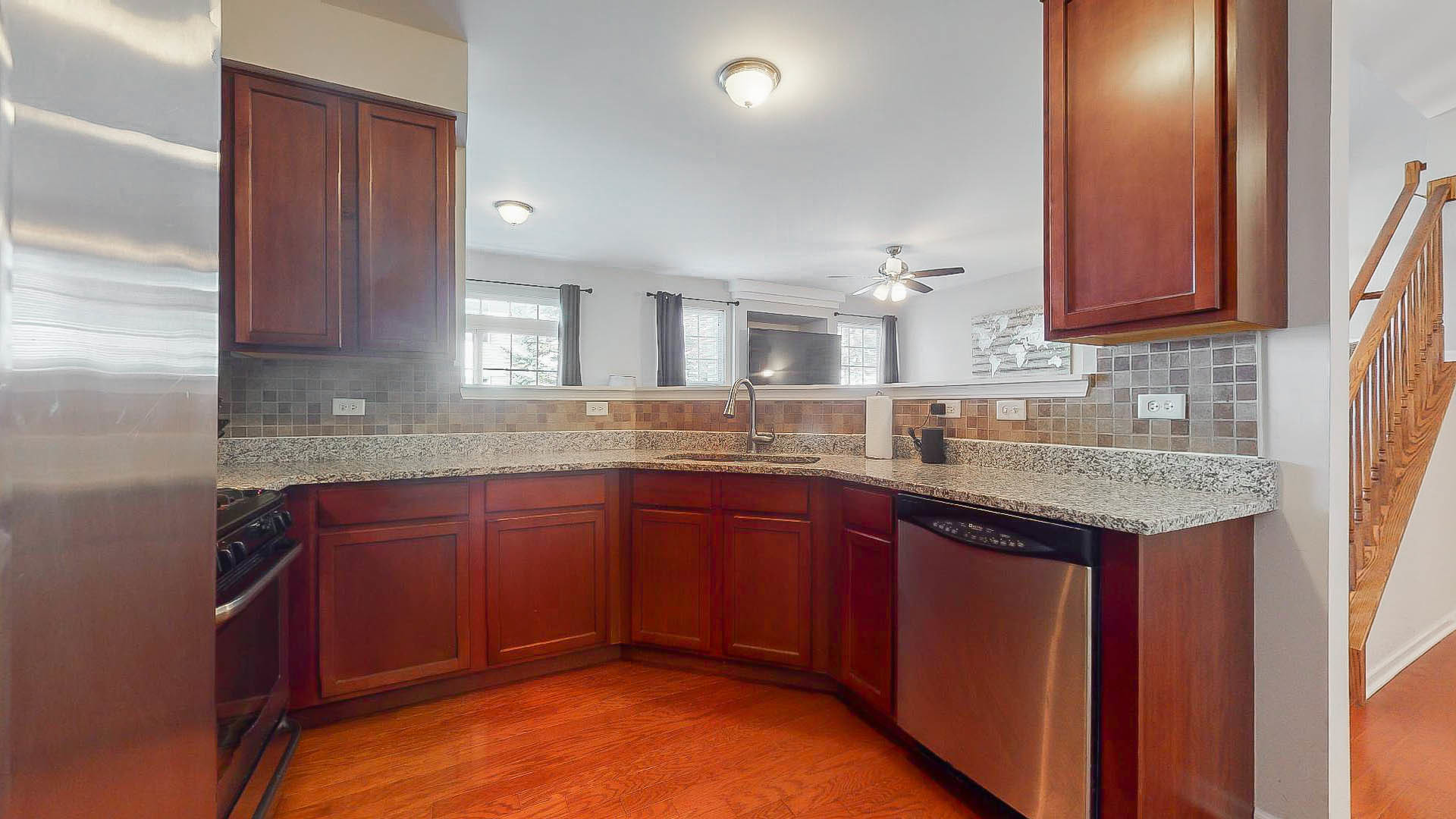 1916 West Cobblestone Road Romeoville, IL 60446 - Photo 8 of 21 a kitchen with granite countertop wooden cabinets and a sink