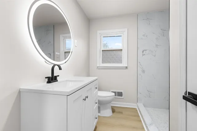 a bathroom with a sink a toilet and a mirror