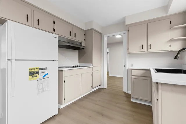a kitchen with a refrigerator and a stove top oven