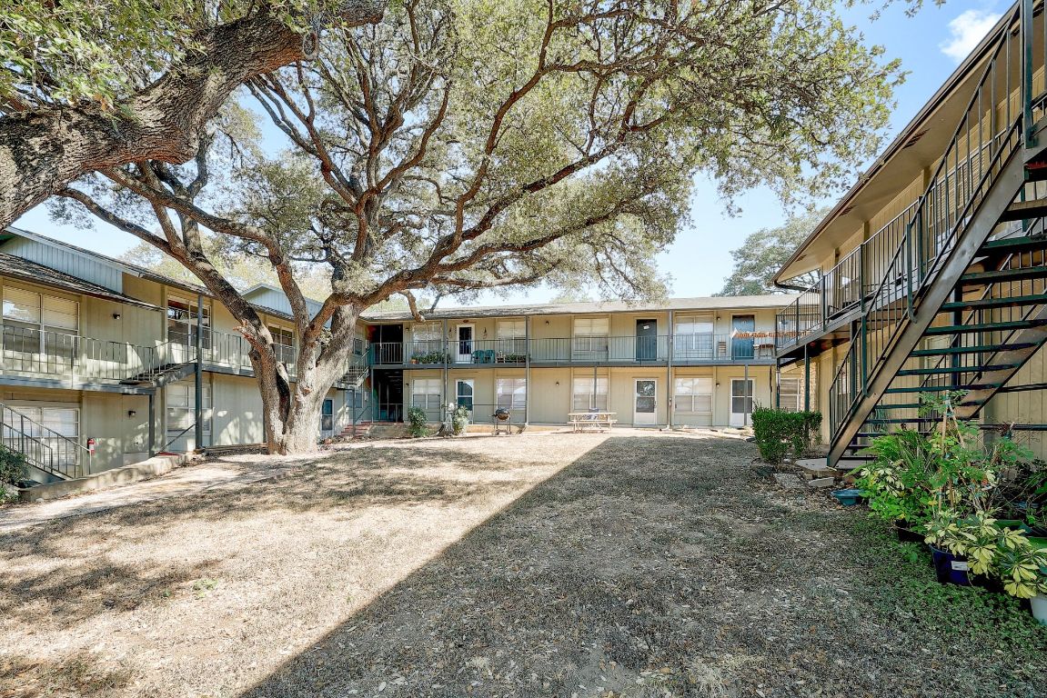 509 Cedar Drive, Unit 207 Georgetown, TX 78628 - Photo 1 of 19 a view of backyard with large trees and wooden fence