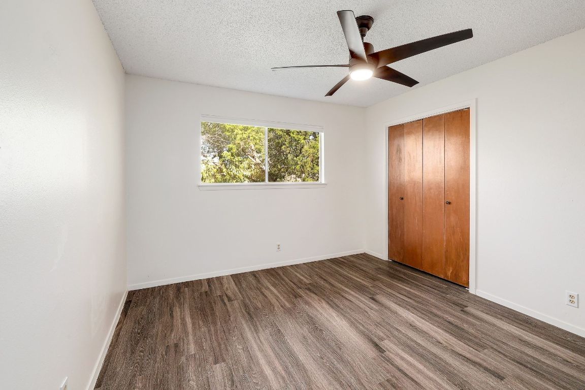 509 Cedar Drive, Unit 207 Georgetown, TX 78628 - Photo 15 of 19 an empty room with wooden floor and ceiling fan