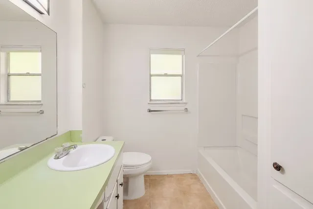 a bathroom with a sink mirror vanity and toilet