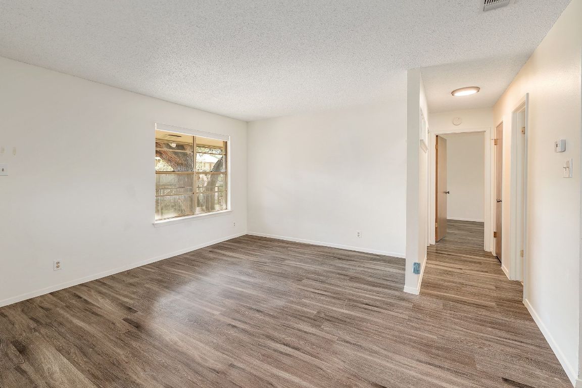 509 Cedar Drive, Unit 207 Georgetown, TX 78628 - Photo 5 of 19 an empty room with wooden floor and windows