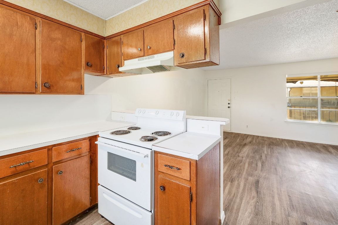 509 Cedar Drive, Unit 207 Georgetown, TX 78628 - Photo 10 of 19 a kitchen with stainless steel appliances granite countertop a sink a stove and a wooden floors
