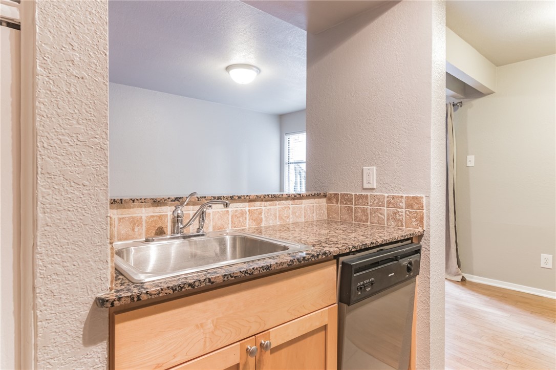 3627 Menchaca Road, Unit 112 Austin, TX 78704 - Photo 10 of 25 Stainless steel sink and granite counter top. Living room in background.