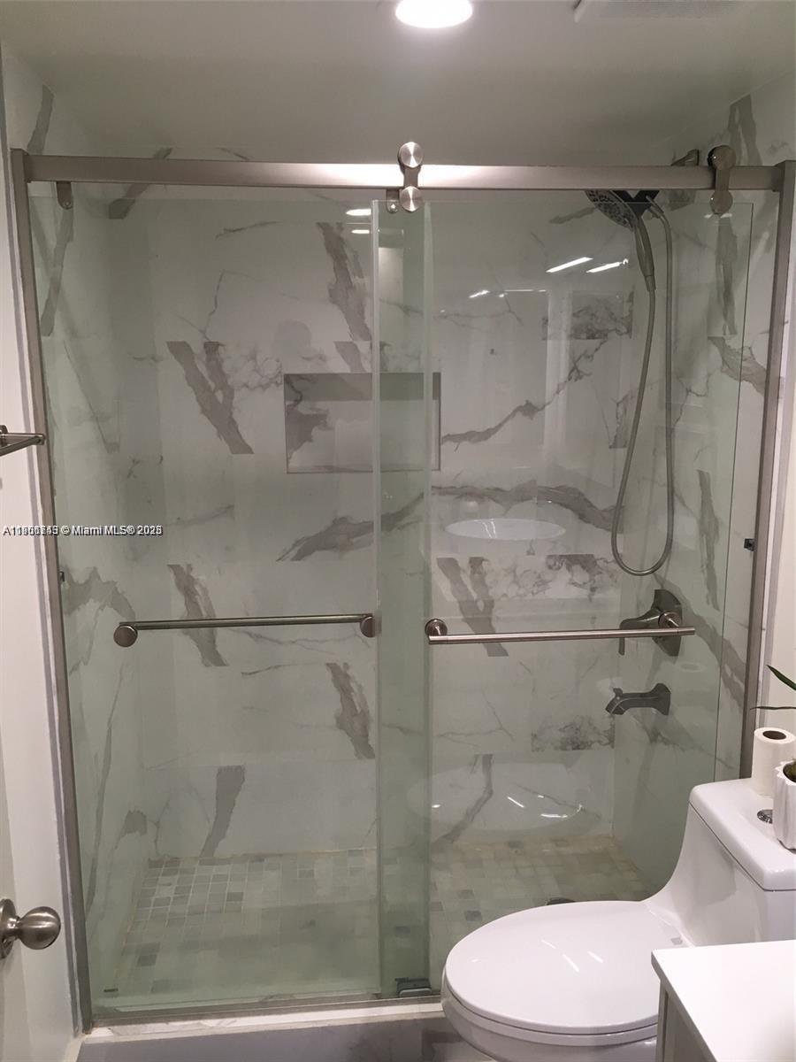 8670 Southwest 212th Street, Unit 108 Cutler Bay, FL 33189 - Photo 4 of 7 a bathroom with a glass shower door