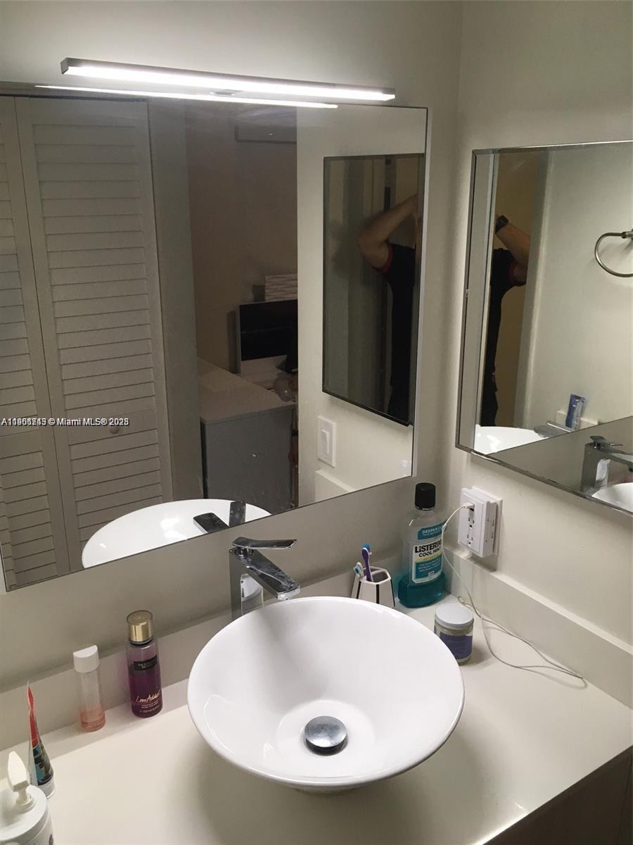 8670 Southwest 212th Street, Unit 108 Cutler Bay, FL 33189 - Photo 5 of 7 a bathroom with a sink and a mirror