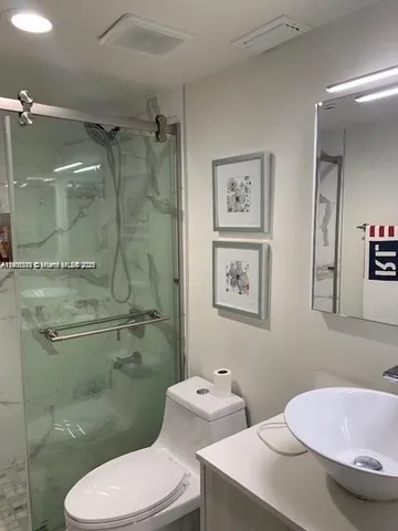 a bathroom with a granite countertop toilet sink and shower