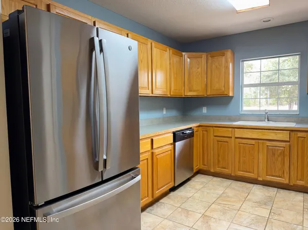 a kitchen with stainless steel appliances granite countertop a refrigerator and a sink