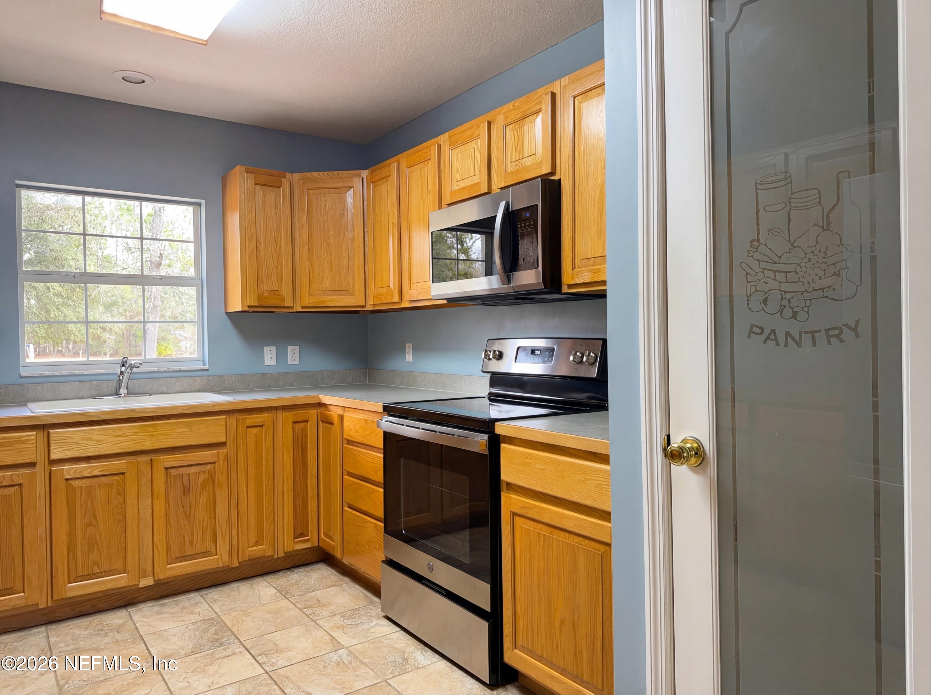 7628 Alameda Way Keystone Heights, FL 32656 - Photo 14 of 29 a kitchen with stainless steel appliances granite countertop a refrigerator and a sink