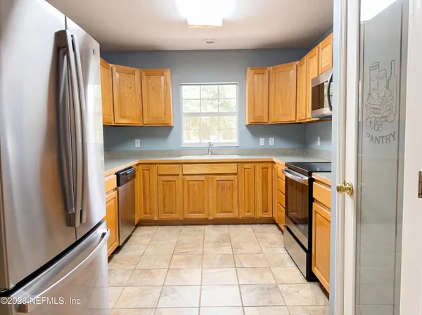 a kitchen with a refrigerator a sink and a window