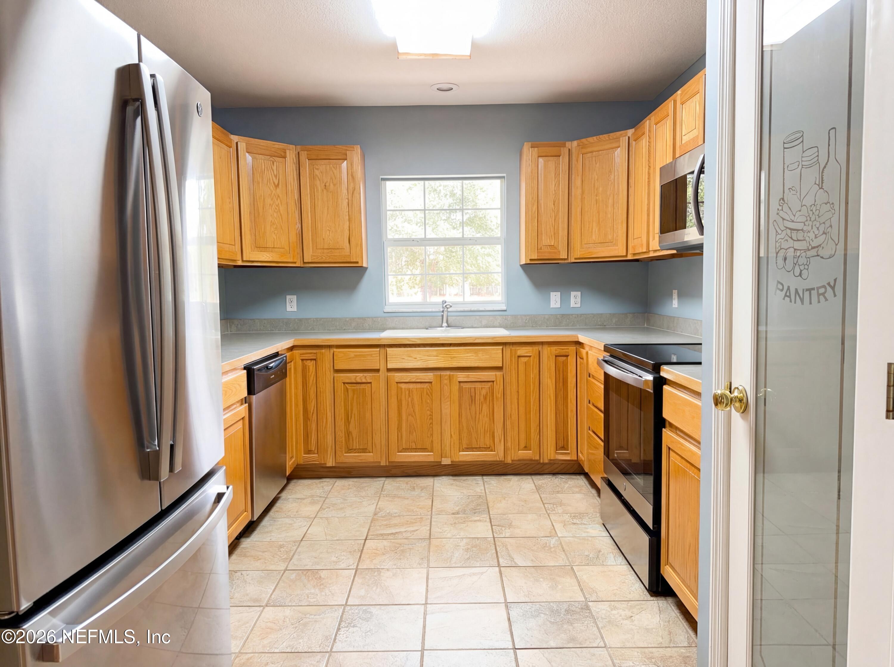 7628 Alameda Way Keystone Heights, FL 32656 - Photo 2 of 29 a kitchen with a refrigerator a sink and a window