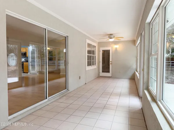 a view of a hallway with wooden floor and a bathroom